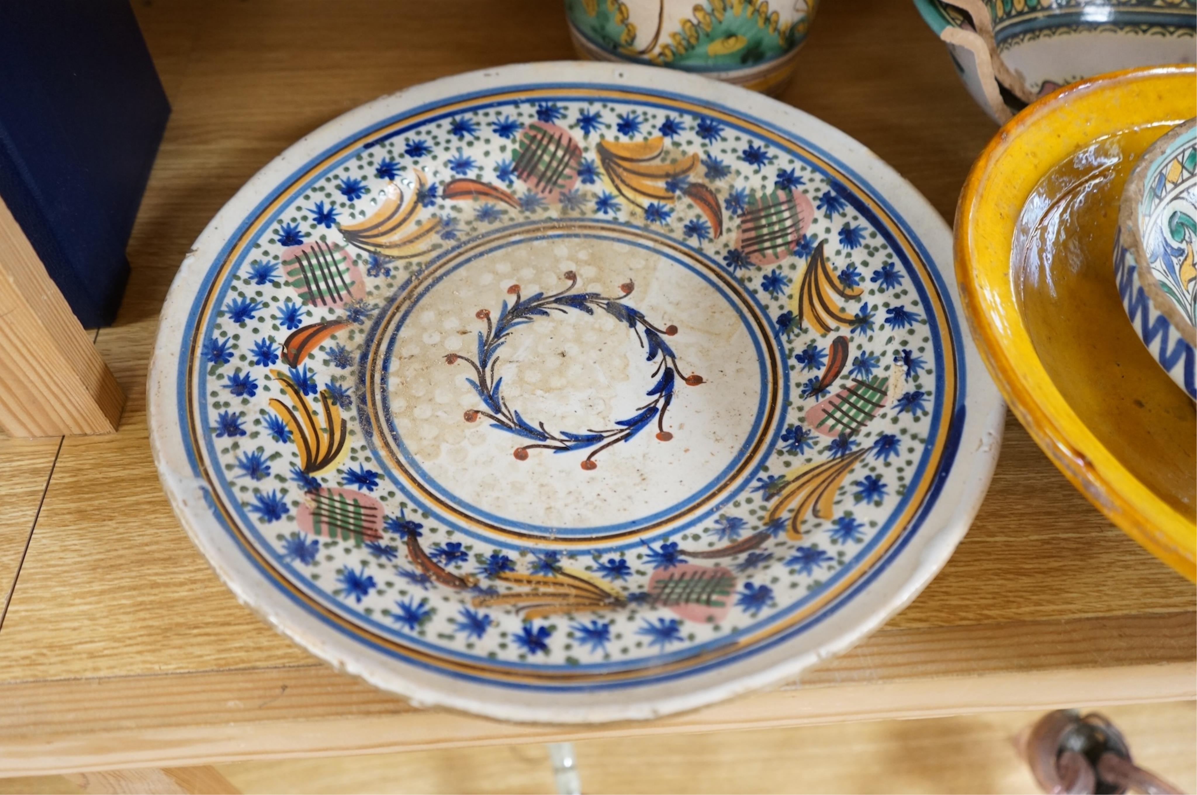 A late 17th century Spanish tin glazed jug together with Moroccan and pottery bowls and dishes (5). Jug 26cm high.